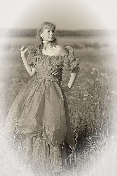 Ung kvinna i en retro klänning i fältet — Stockfoto