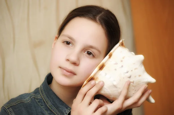 Tiener meisje luisteren naar de lawaai-shell — Stockfoto