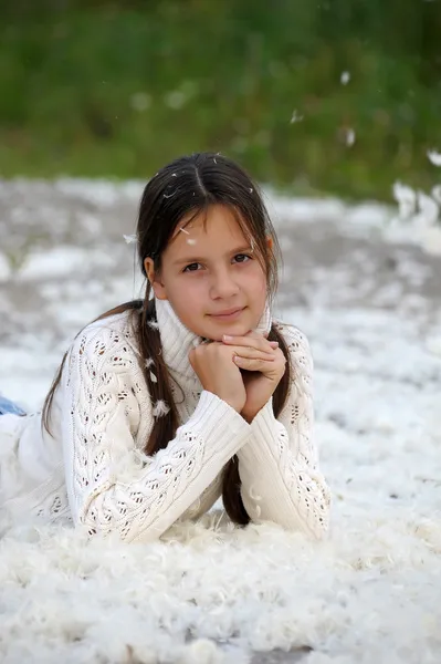 Молода красива дівчина заповнена маленьким пір'ям — стокове фото