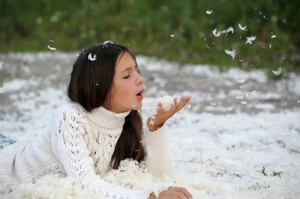Young beautiful girl filled up by small feathers — Stock Photo, Image