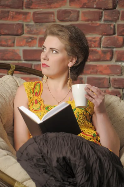 Nő egy könyvet és egy csésze, elnök. — Stock Fotó