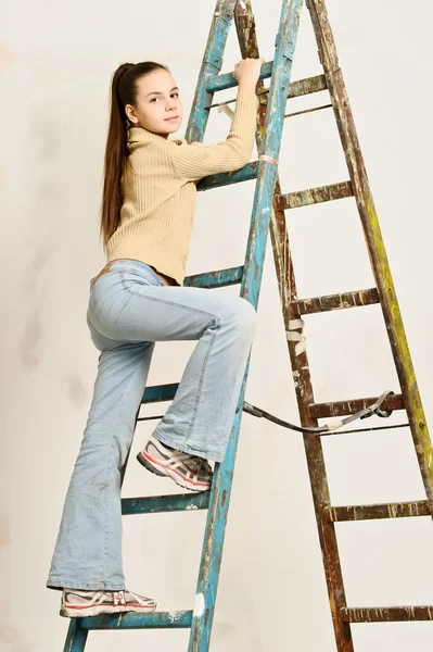 O adolescente a menina levanta-se em uma escada de mão — Fotografia de Stock