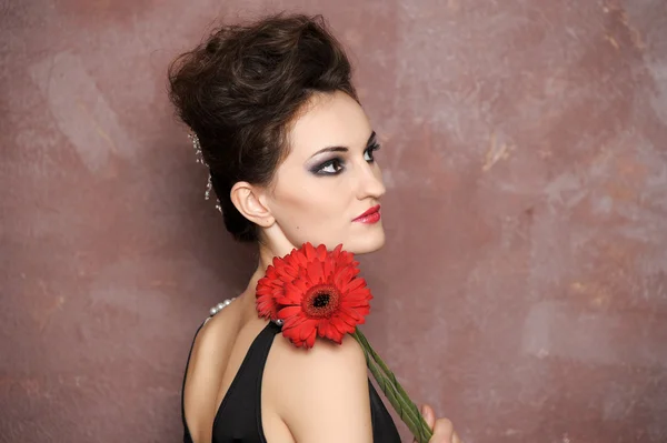 Mulher atraente com flores vermelhas — Fotografia de Stock