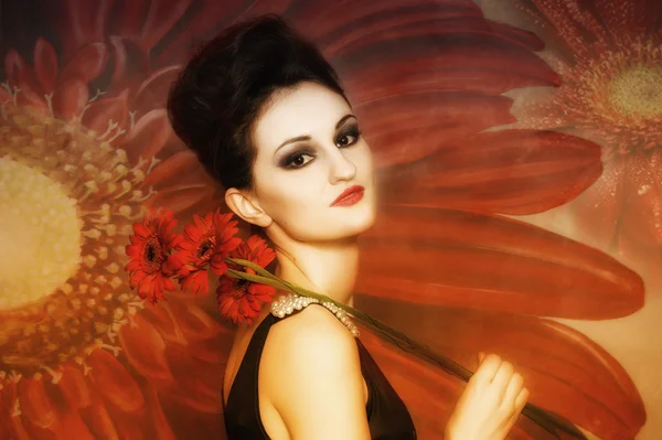 Attraktiv kvinna med röda blommor — Stockfoto