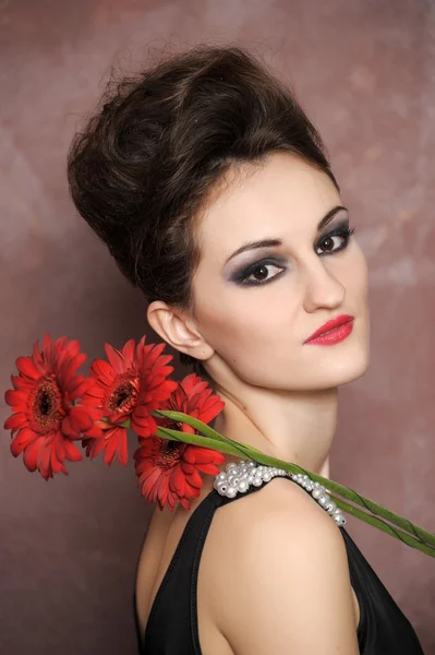 Çekici bir kadın kırmızı çiçekli — Stok fotoğraf