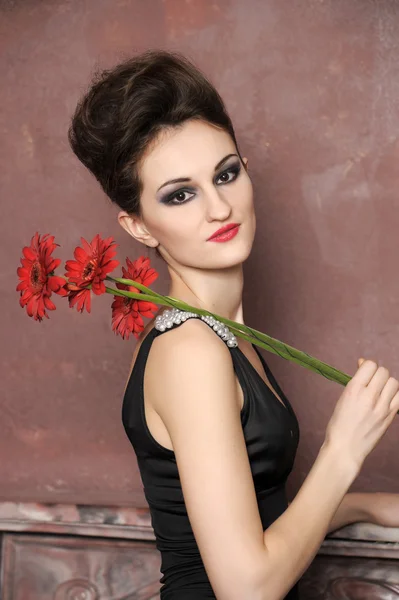 Vonzó nő, piros virágokkal — Stock Fotó