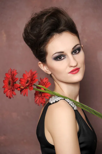 Atraktivní žena s červenými květy — Stock fotografie