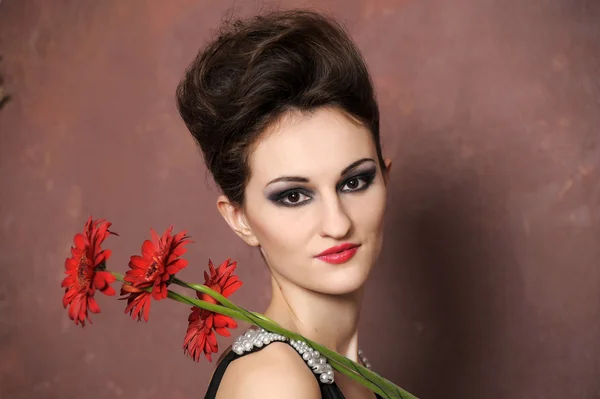 Mujer atractiva con flores rojas —  Fotos de Stock