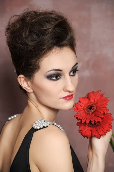 Donna attraente con fiori rossi — Foto Stock