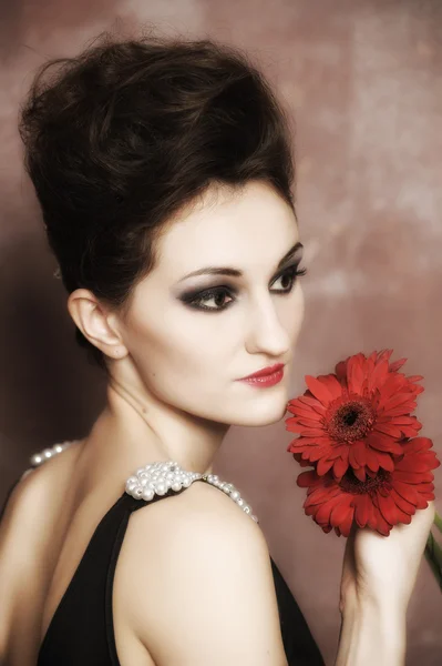 Приваблива жінка з червоними квітами — стокове фото