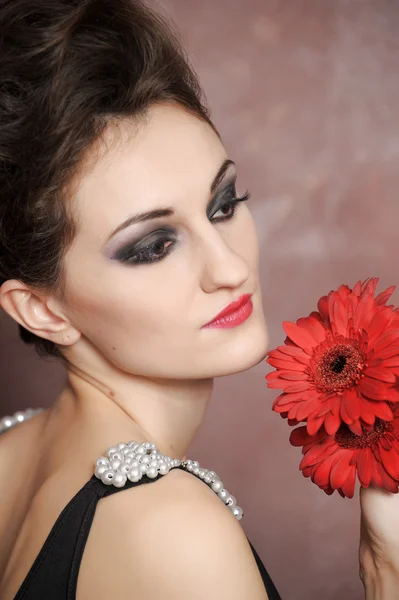 Attractive woman with red flowers — Stock Photo, Image