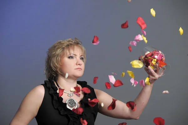 Kvinna och kronblad av rosor — Stockfoto