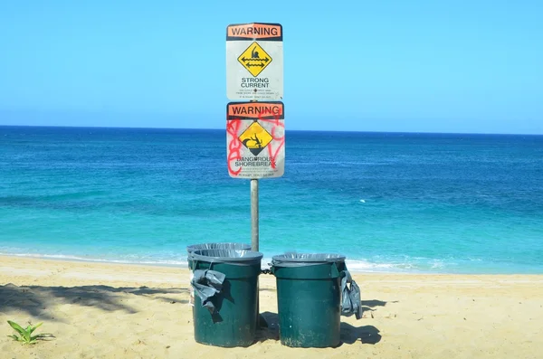 Warnschilder und Mülltonnen am Strand — Stockfoto