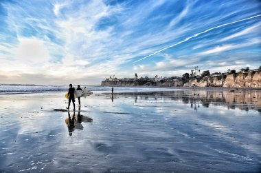 Sunset at the beach of San Diego with surfers clipart