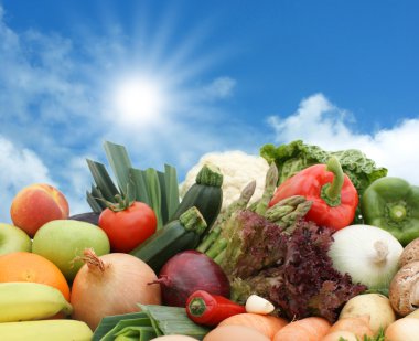 Fruit and vegetables against a sunny sky clipart