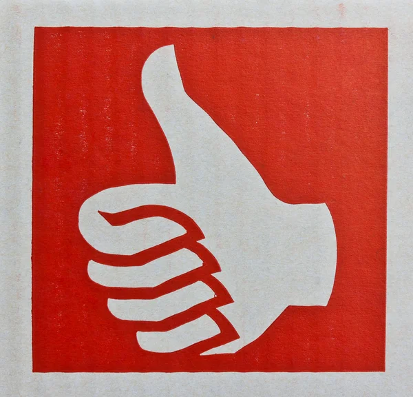 Palec nahoru, jako symbol v červeném pozadí — Stock fotografie