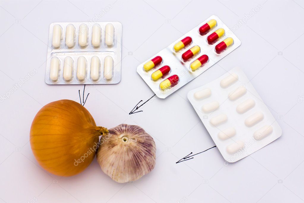Onions, garlic and medicines on a light background