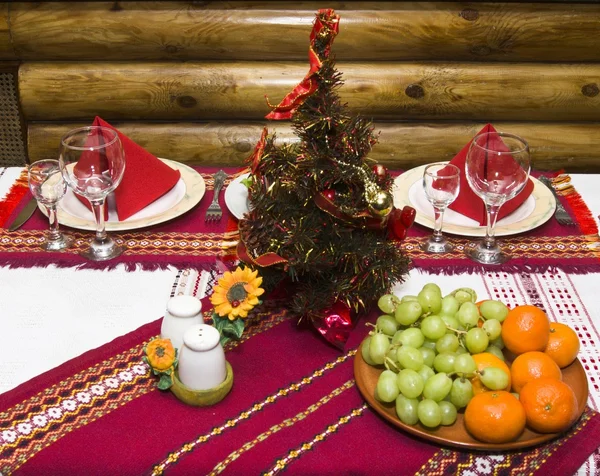 Árbol de Navidad, copas de frutas y vino sobre la mesa —  Fotos de Stock