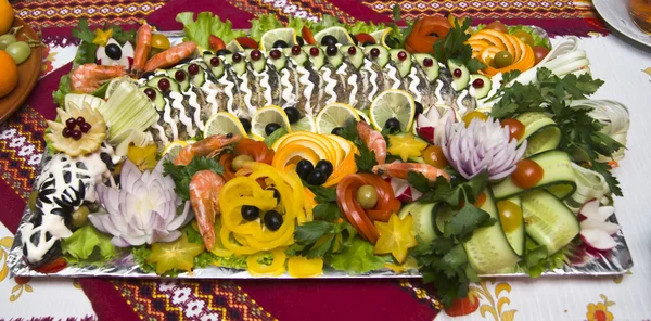 Фаршированный Пайк на блюдечке с овощами на столе . Стоковое Фото