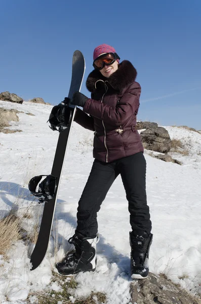 Улыбающаяся молодая женщина со сноубордом — стоковое фото