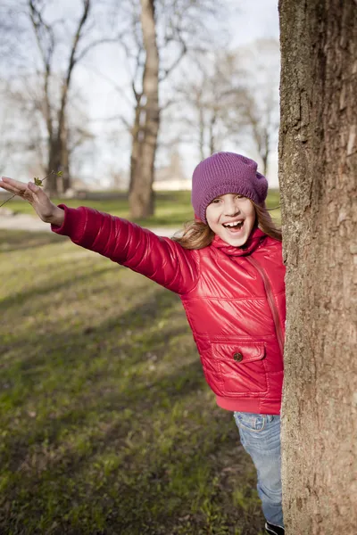 Sonriente chica en edad escolar está en el parque —  Fotos de Stock