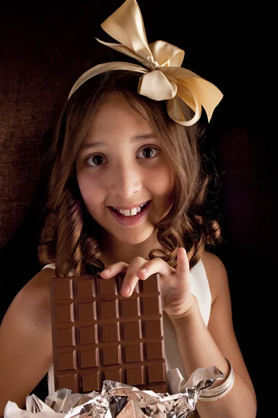 stock image Girl with the big chocolate and with bow on a head looking at camera