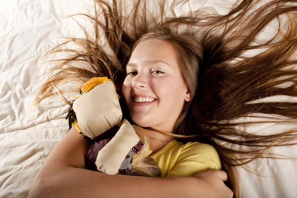 Girl with doll on the bad — Stock Photo, Image
