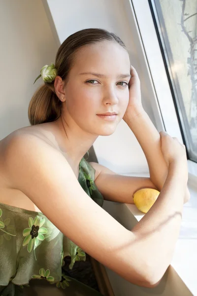 Piękna dziewczyna z cytryny w pobliżu okna — Zdjęcie stockowe