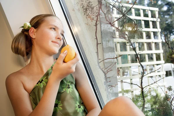 Menina bonita com limão perto da janela Fotos De Bancos De Imagens