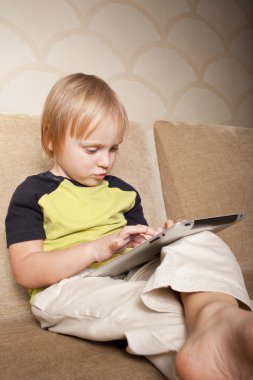 Positive small boy with tablet computer clipart