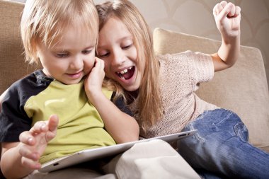 Smiling girl and boy with tablet computer clipart