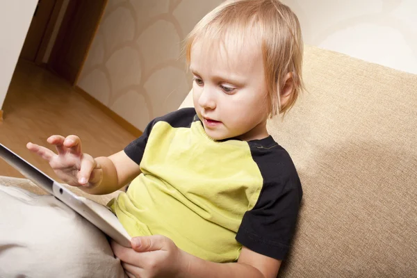 Pozitivní malý chlapec s tabletovým počítačem — Stock fotografie