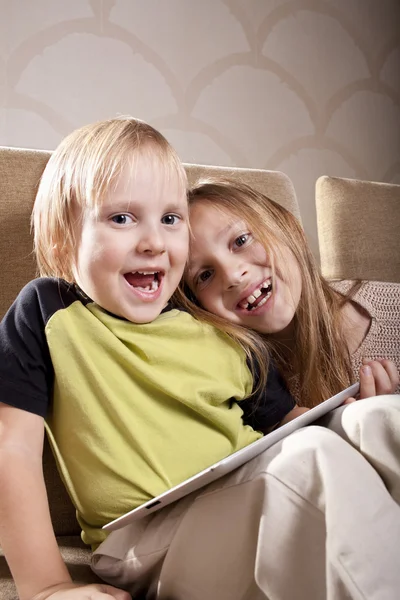 Usmívající se dívka a chlapec s tabletovým počítačem — Stock fotografie