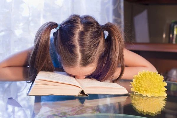 La colegiala baja la cabeza ante el libro — Foto de Stock