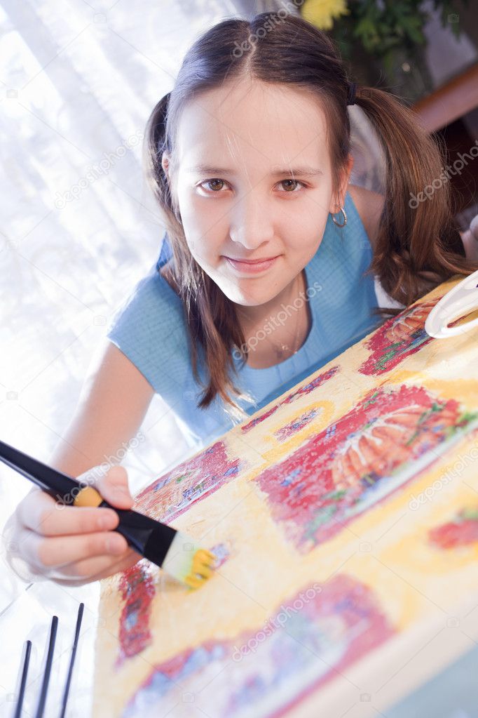 Positive schoold girl are painting at home