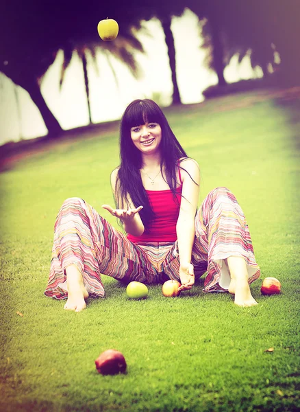 Elmalı yeşil çayır üzerinde güzel bir genç kadın — Stok fotoğraf