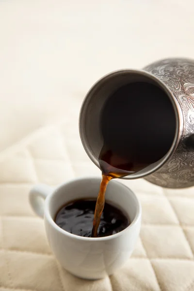 Verser le café dans une tasse blanche — Photo