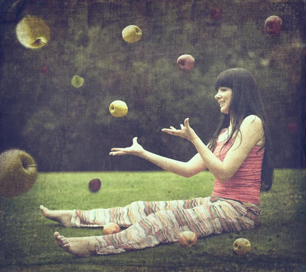 Hermosa joven en el prado verde con manzanas — Foto de Stock