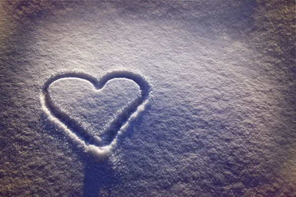 Білий сніг з потопленою формою серця — стокове фото