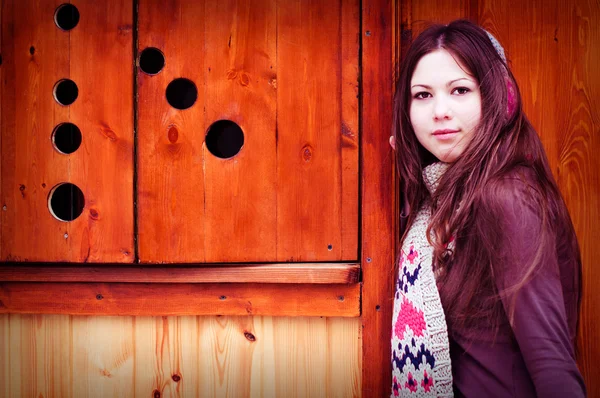 Vrouw in de buurt van een houten muur — Stockfoto