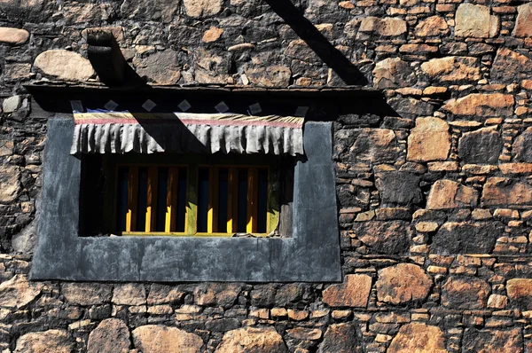 Типичное тибетское окно и каменная стена — стоковое фото