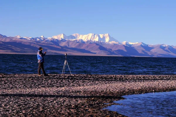 Пейзаж на берегу озера с силуэтом фотографа — стоковое фото