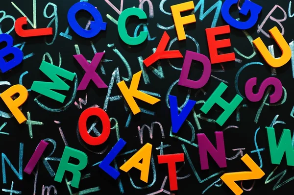 Kleurrijke willekeurige letters op een schoolbord — Stockfoto