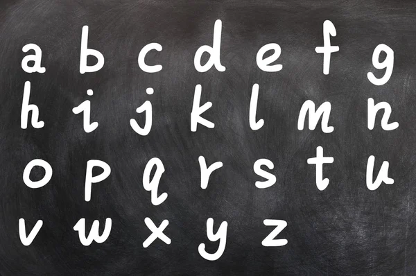 Alfabeto inglés escrito a mano con tiza blanca en una pizarra — Foto de Stock