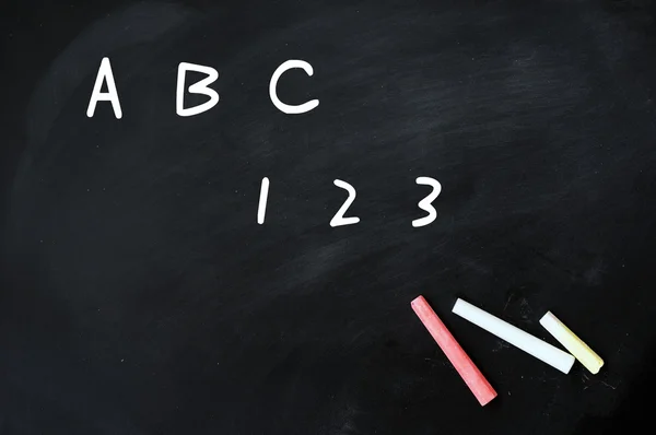 ABC och 123 handskrivna med vit krita på en svart tavla — Stockfoto