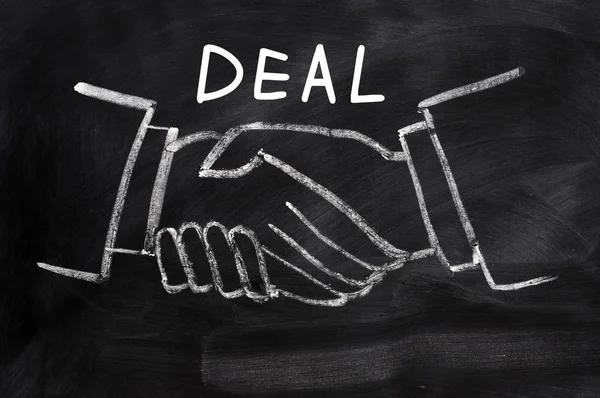 Zakelijke deal geschreven op een schoolbord achtergrond met handshaking — Stockfoto