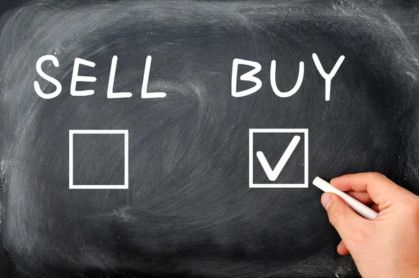 Buy or sell check boxes written on a blackboard — Stock Photo, Image