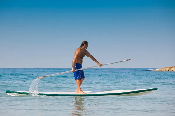 De man met een riem op een surfplank. — Stockfoto