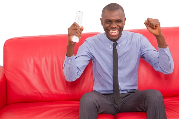 Man on the sofa with remote control rejoice — Stock Photo, Image