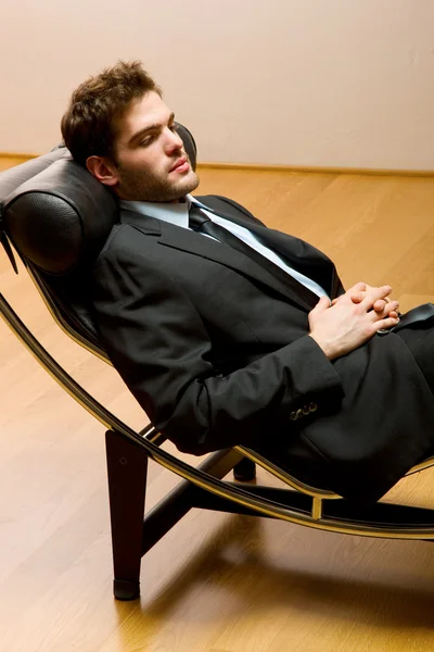 Man som ligger på schäslong — Stockfoto